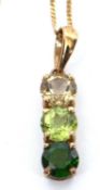 A 9k three green stone pendant and chain, the pendant set with three round faceted green