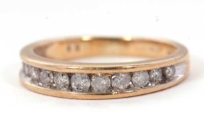 A 9ct diamond ring, the upper half with graudated channel set round brilliant cut diamonds, total