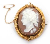 A cameo brooch, the oval shell cameo of a classical maiden with vines in her hair, in yellow metal