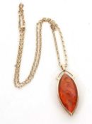 A 9ct amber pendant and chain, the marquise shape amber pendant in a frame with tapered bale stamped