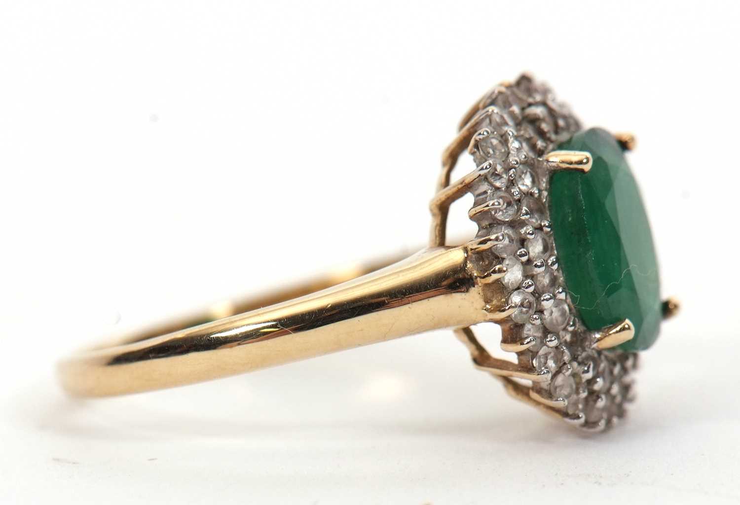 A 9ct emerald and diamond cluster ring, the oval emerald, approx. 9mm long, surrounded by two rows - Image 6 of 6