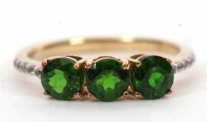 A 9ct diopside and white stone ring, the three round diopside with quarter set white stone