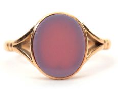 An 15ct agate signet ring, the oval unmarked agate disc, in collet mount with split shoulders and