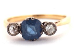 A sapphire and diamond ring, the central pale blue sapphire set to either side with an illusion