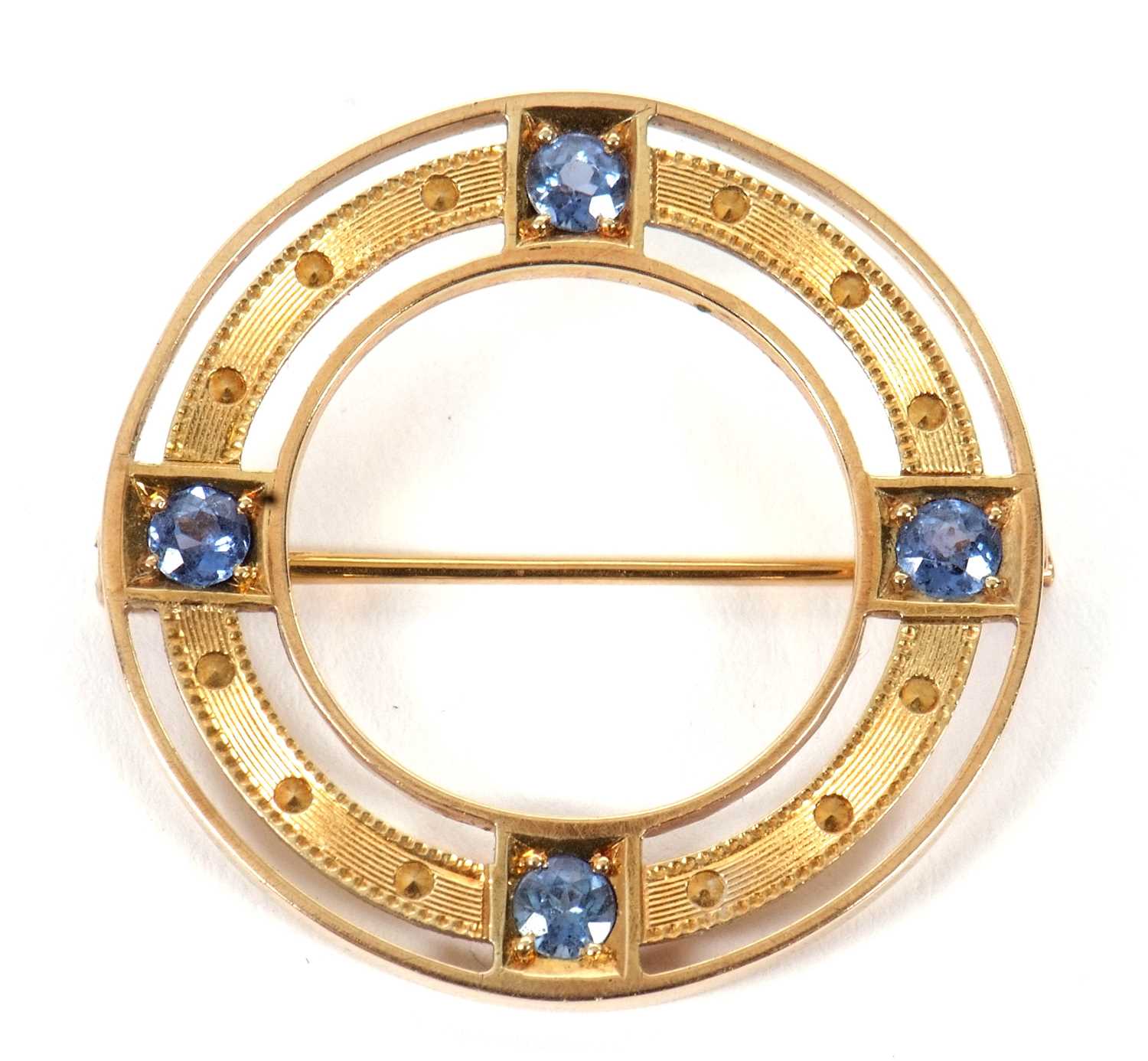 A late 19th/early 20th century sapphire brooch, the ring set with four pale blue sapphires, all