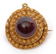 A garnet cannetille pendant/brooch, the round garnet cabochon with closed back, surrounded by two