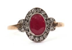 A 15ct ruby and diamond ring, the oval mixed cut ruby, collet mounted and surrounded by small