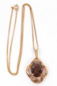 A smokey quartz pendant, the oval smokey quartz set within an openwork scalloped frame with