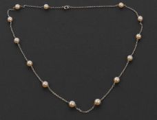 A cultured pearl necklace, set with 5mm cultured pearls interspaced with short lengths of unmarked