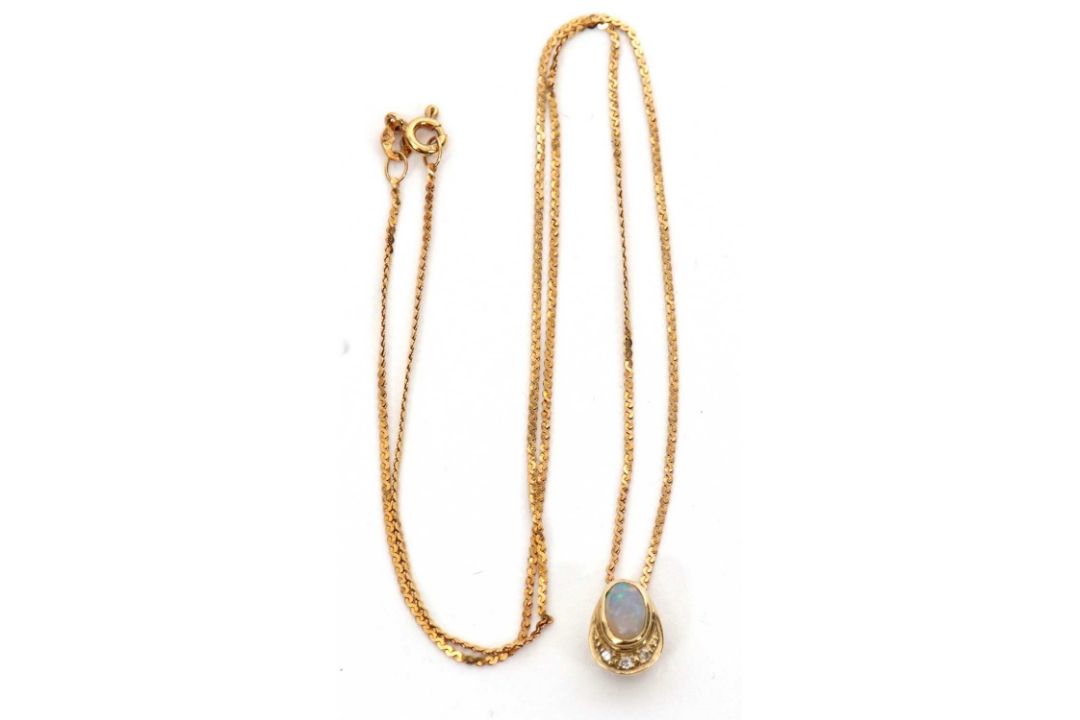 A 9ct opal and diamond pendant necklace, the oval opal cabochon in a pear shape mount with diamond - Image 1 of 4