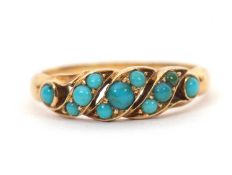An unmarked turquoise ring, set with small round turquoise cabochons, with tapered shoulders and