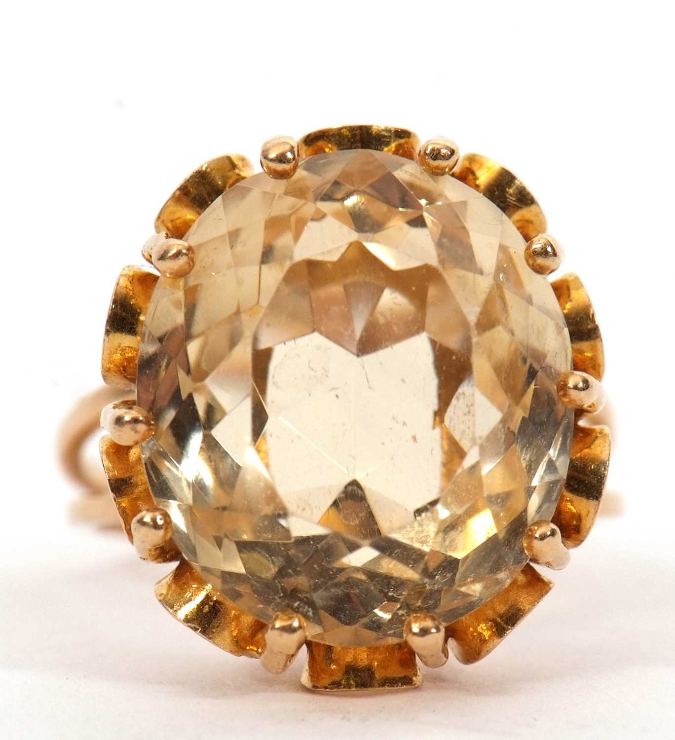 A citrine ring, the oval mixed cut citrine, approx. 16mm long, claw mounted with looped gallery,