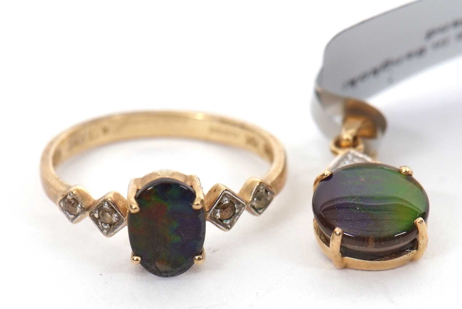A 9ct opal triplet ring and a matching 10K pendant, the oval opal triplet in a four claw mount