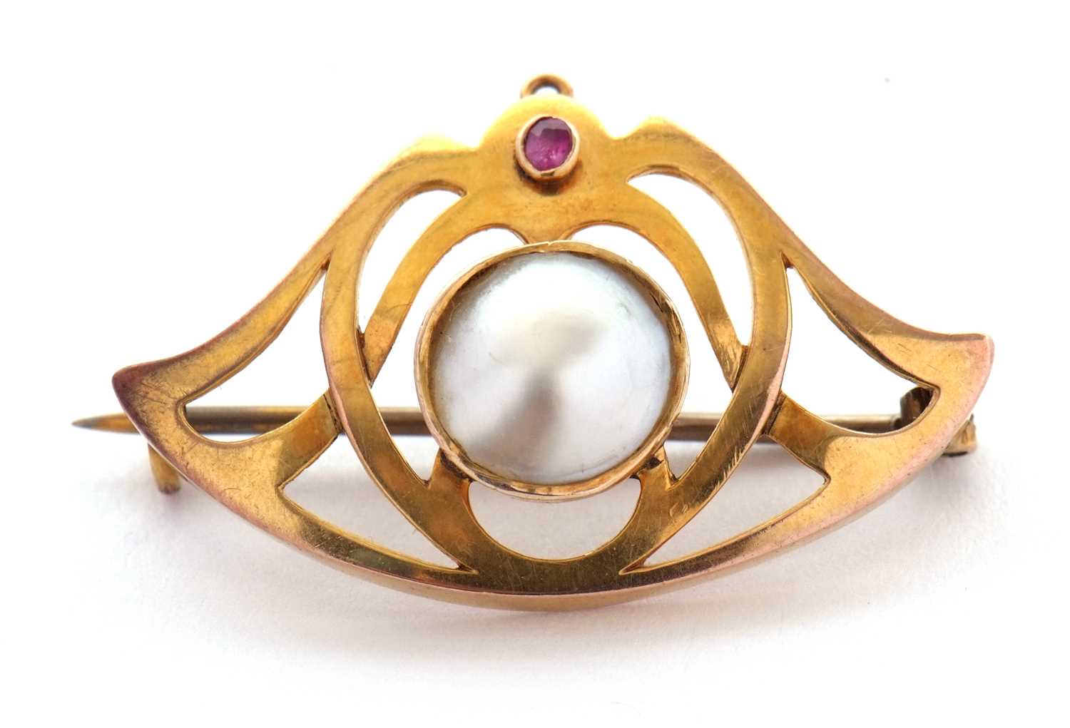 An Art nouveau brooch, the central round blister pearl, collet mounted within a frame set with a