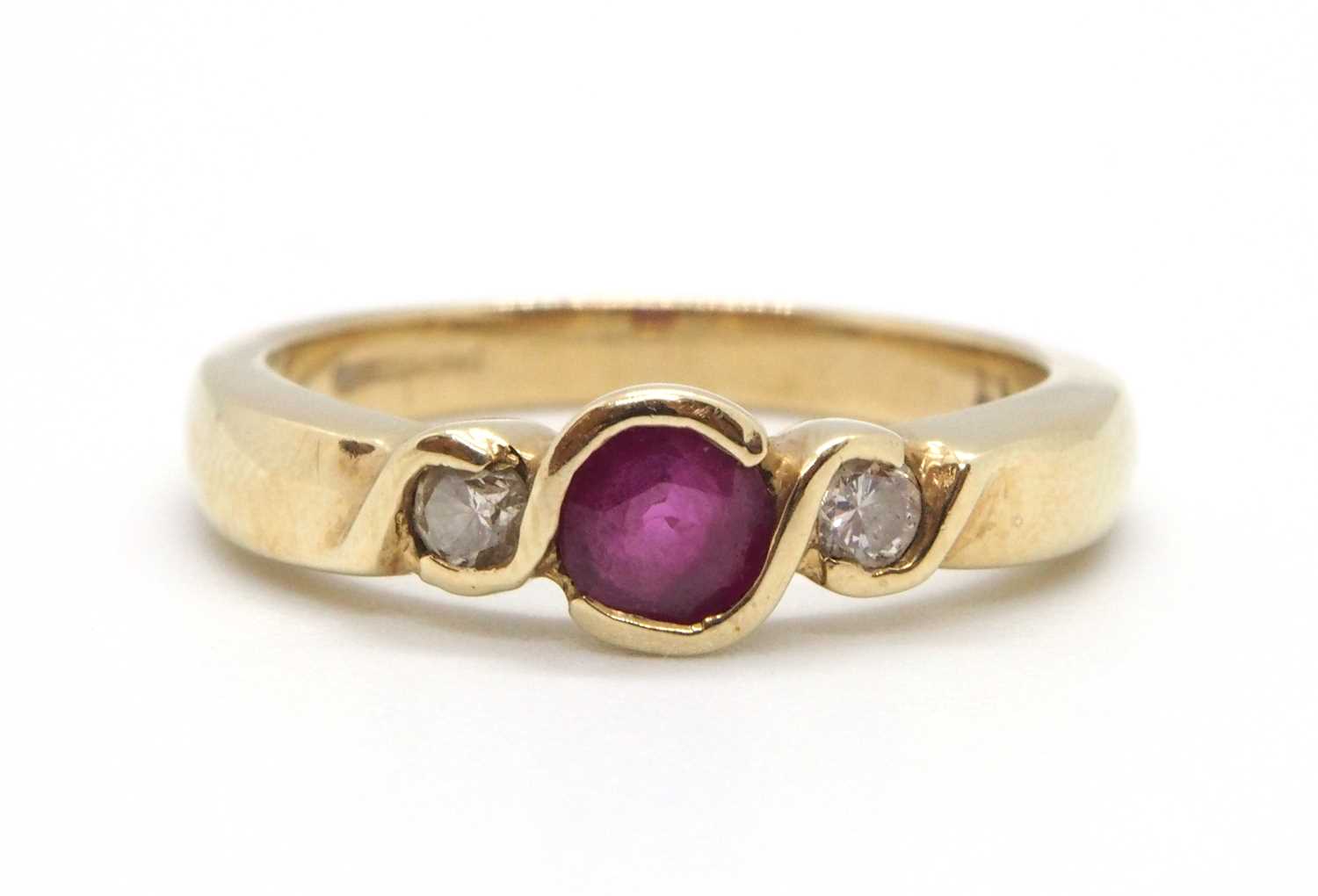 A 9ct ruby and diamond ring, the round collet mounted ruby with a round brilliant cut diamond to