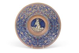 A Cantagalli lustre dish decorated in Hispano-Moresque style with a cherub to the centre on blue