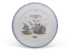 An 18th Century Delft charger with polychrome design, probably Bristol, 33cm diameter