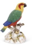 A large Meissen model of a parakeet seated on a rocky base decorated in bright colours, cancelled