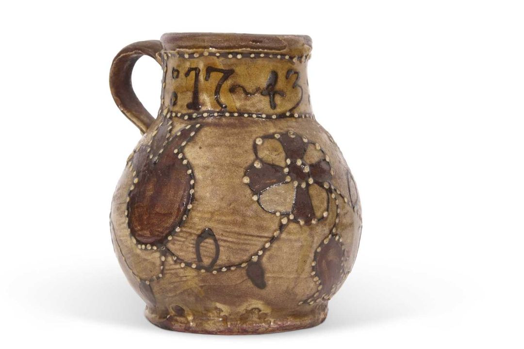 An early 18th Century pottery mug, possibly Devon slip ware decorated with tulips and dated 1743, - Image 1 of 7