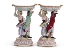 A pair of 19th Century Meissen Sweetmeat figures modelled as a boy and a girl with bowl above,