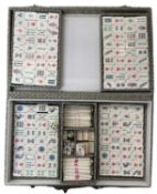 A vintage Mahjong set, within a silk-covered case