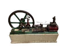 A large single cylinder horizontal stationary steam engine, mounted to composite base, together with