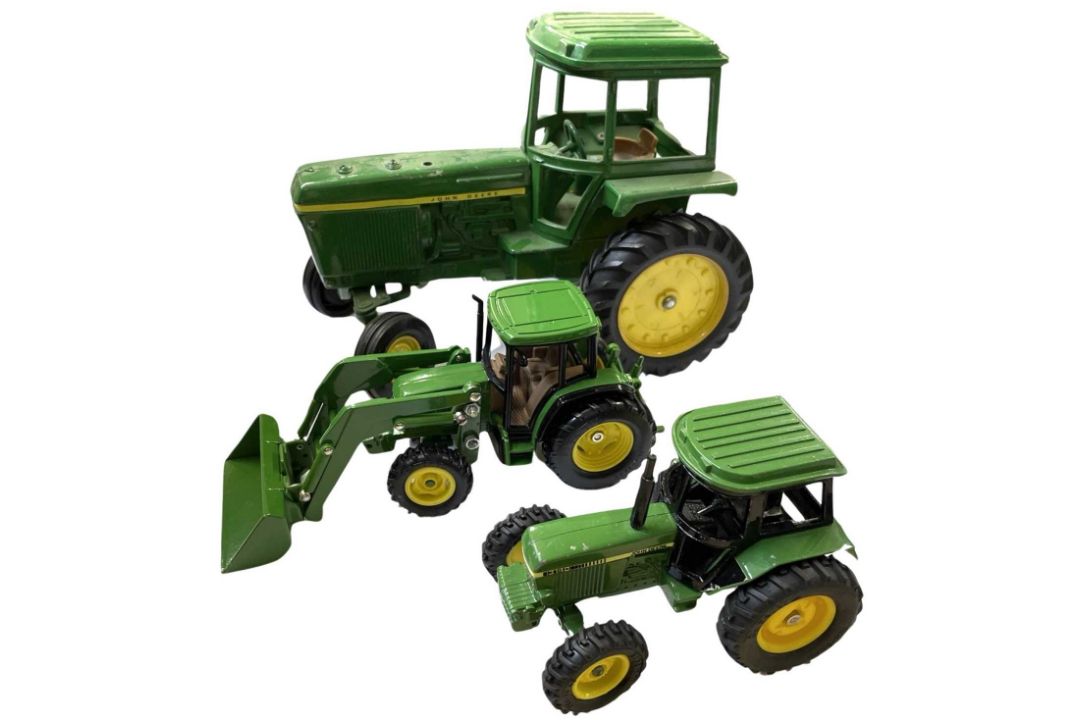 Two die-cast John Deere tractor models, plus one other.