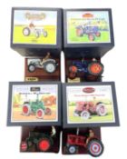 Four boxed Britains die-cast tractor models on wooden plinths, to include: - David Brown 900 -