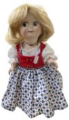 A reproduction German bisque head googly eye-eye doll, in patterned dress with blonde hair and