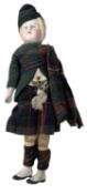 A small vintage bisque head doll, formed as a boy in Traditional Highland dress. With cloth body and