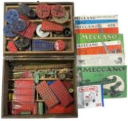 A wooden box containing a quantity of vintage Meccano and various manuals