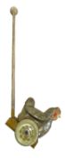 A push-along tinplate toy chicken with moving wings, wood handle and clucking sounds