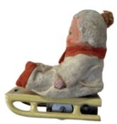 A vintage German clockwork toy modelled as a boy on a sledge. (lacking key)