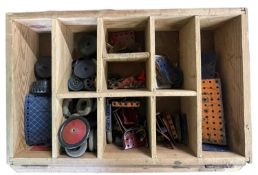 A wooden box containing a quantity of vintage meccano
