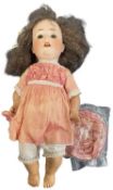 A Porzellanfabrik Burggrub bisque head doll with brown eyes, open mouth and teeth showing, wearing