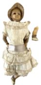 An antique doll with wax head, shoulders and limbs, sewn to cloth body. One eye loose within