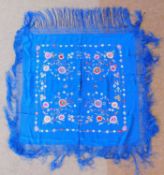 A late 19th/early 20th century blue silk embroidered shawl, covered with embroidered flowers and