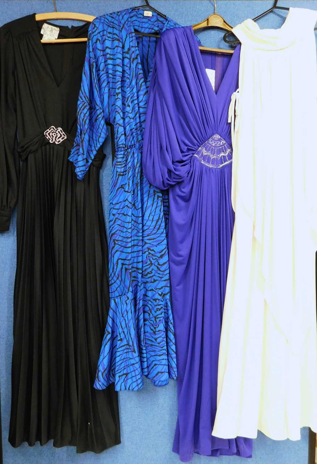 Four circa 1970's/80's evening dresses: to include a cream sleeveless cowl neck dress by Shubette, a