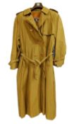 A lady's double breasted Burberry trench coat, in green check with brown buttons, belted waist and
