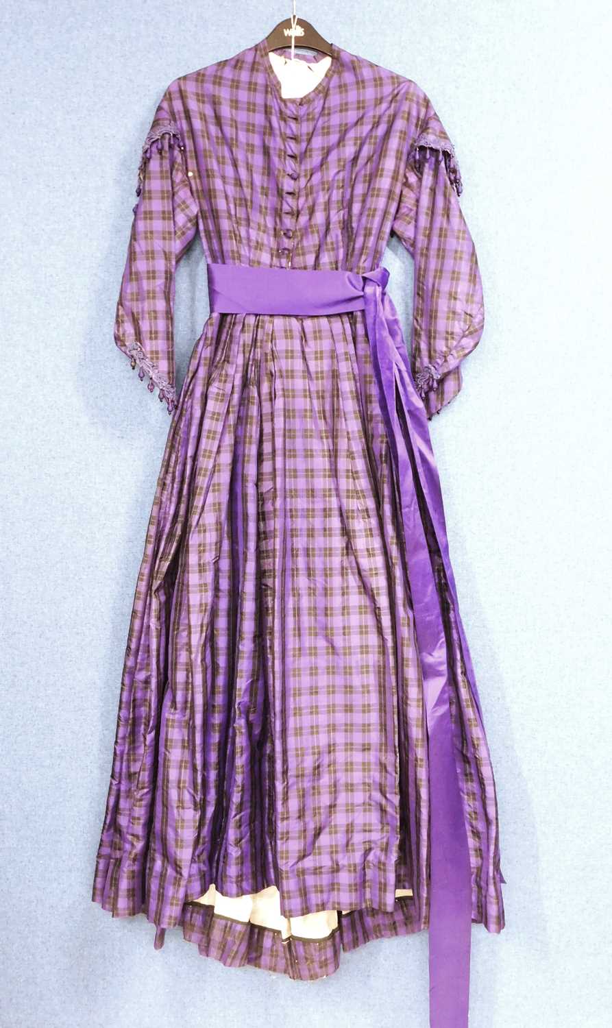 A lady's late Victorian purple check day dress, with button front, full skirt, sash waist, braided