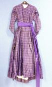 A lady's late Victorian purple check day dress, with button front, full skirt, sash waist, braided