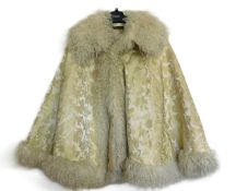 A cream and gilt brocade fur trimmed cape, by Woolright & Co., Liverpool, with turn up collar, satin