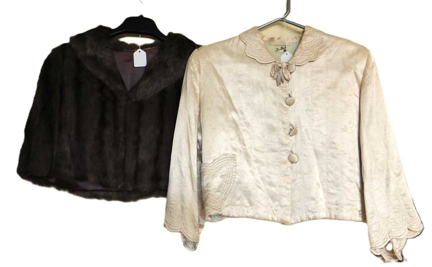 A mid 20th century lady's satin cropped jacket, together with a taupe coloured fur shoulder cape, (