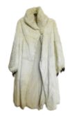 A lady's full length cream fur coat, with high turn up collar and balloon cuffed sleeves with