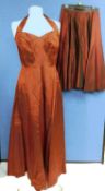 A ladies burgundy halter neck evening gown with fitted ruched bust, zip back together with