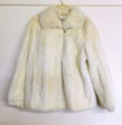 A cream mink(?) fur jacket, with turn up collar and hook fastening