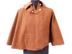 An early 20th century lady's brown felt cape, with double buckle fastening to neck and portcullis
