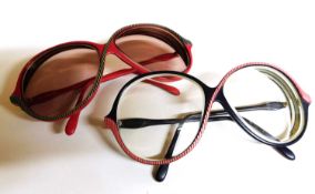 Two pairs of Oliver Goldsmith c.1980's crossover 'zig zag' spectacles, one in red the other in blue,