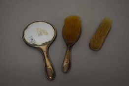 A three piece silver backed dressing table set