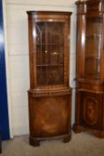 A mahogany finish corner display cabinet